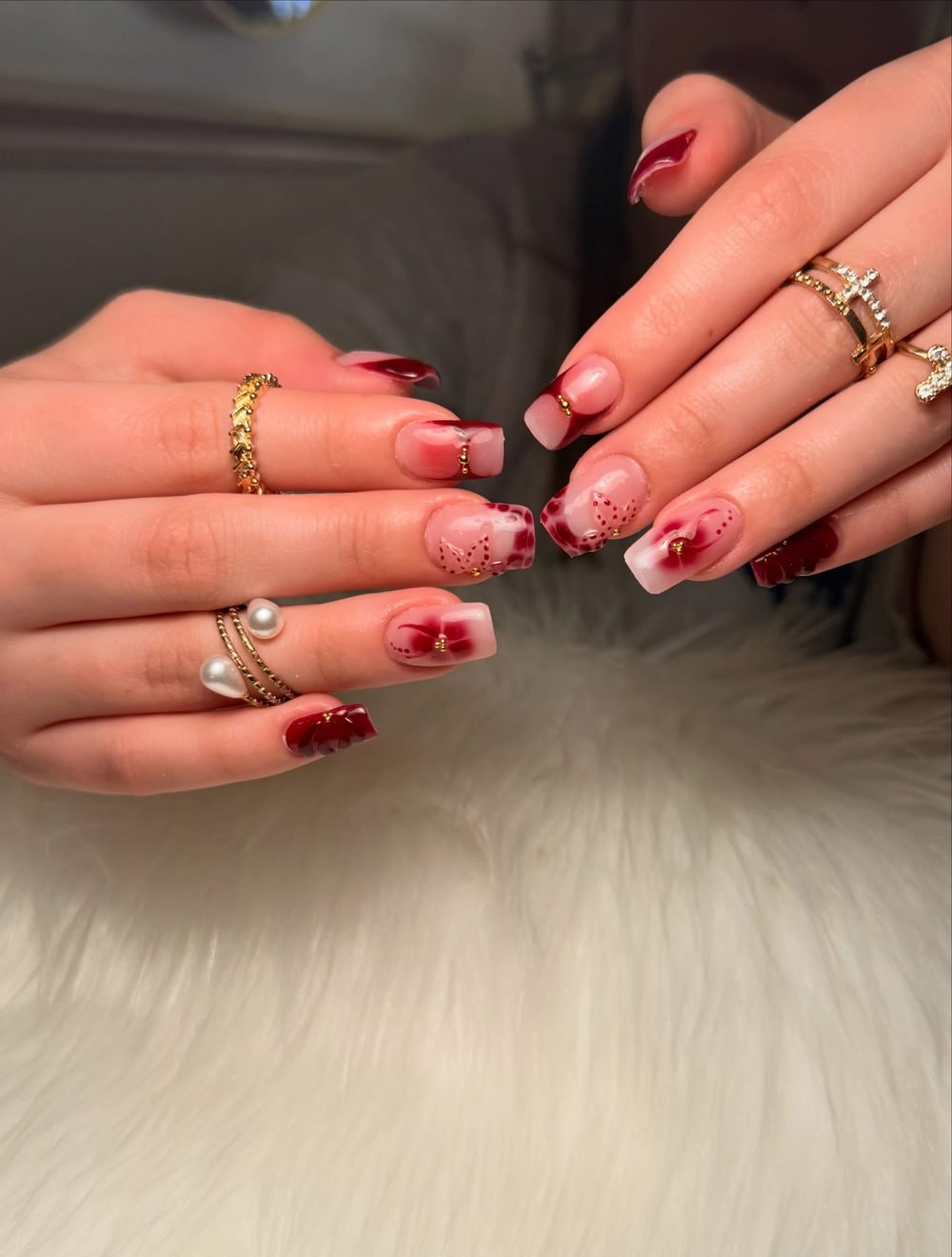 Burgundy hand-painted floral nail art on a nude base